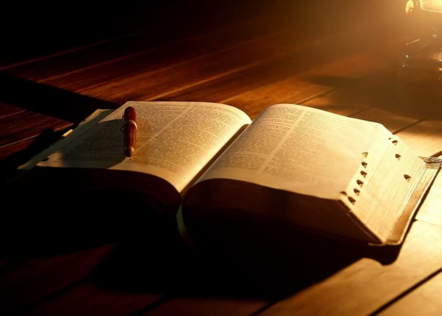 открытая библия и ручка при свете лампы читать библию